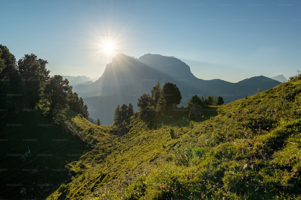 the sun is shining over the mountains and trees