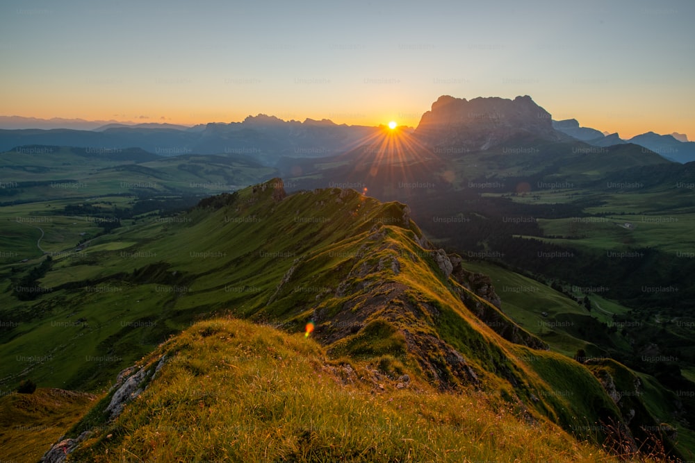 the sun is setting over a mountain range