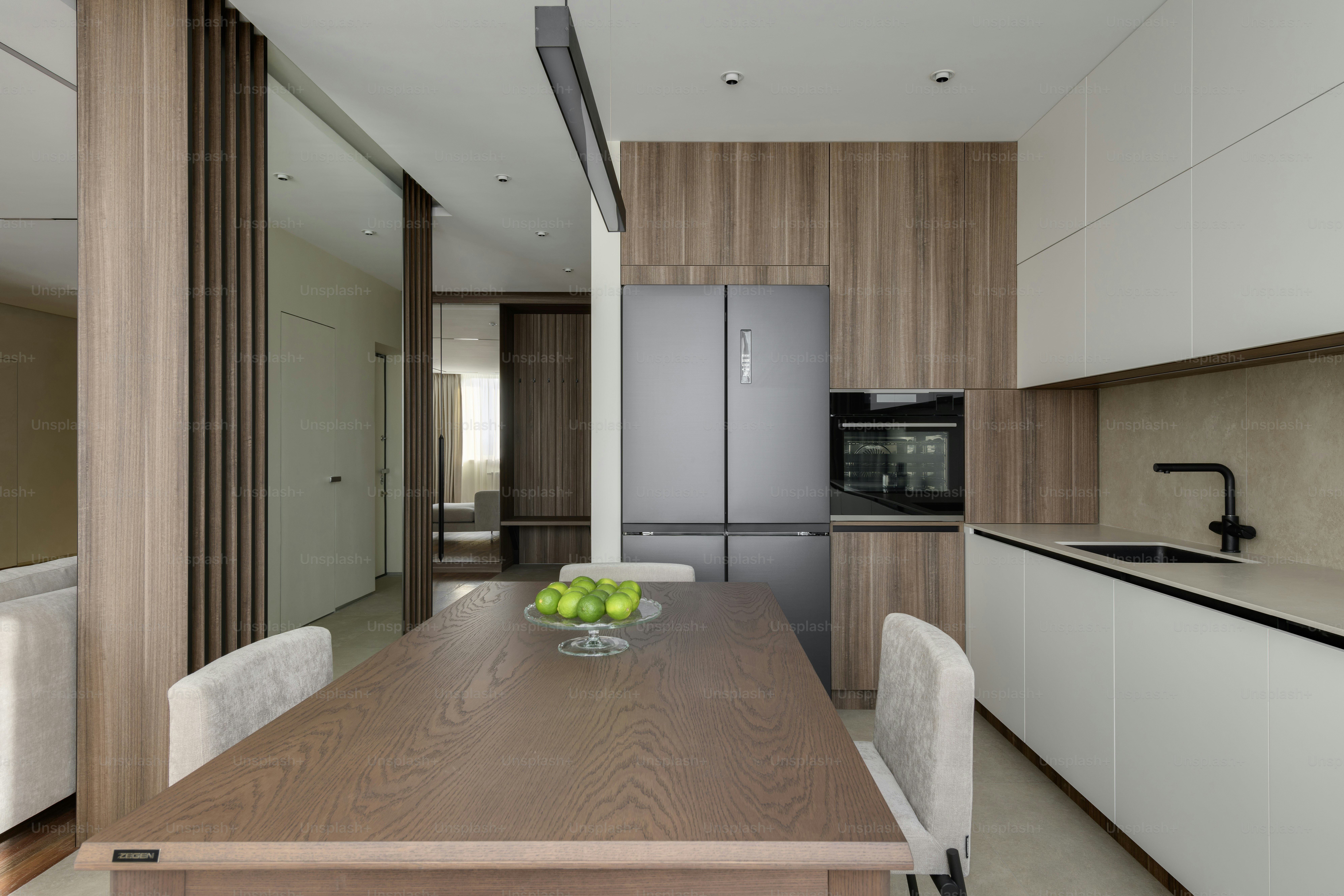 una cocina con una mesa de madera y sillas blancas
