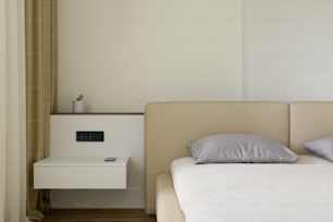 a white bed sitting next to a white night stand