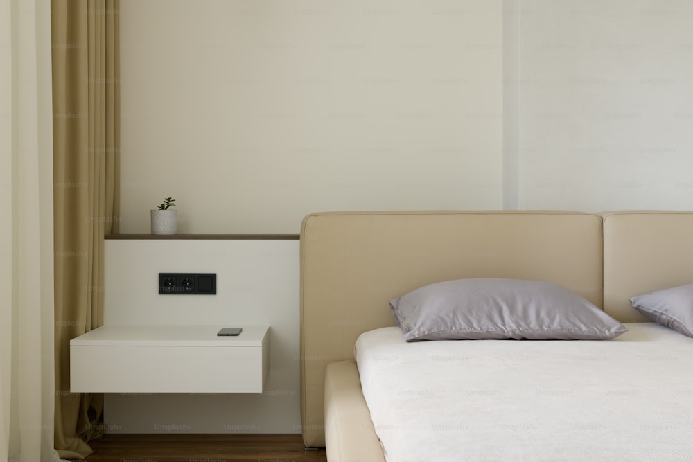 a white bed sitting next to a white night stand