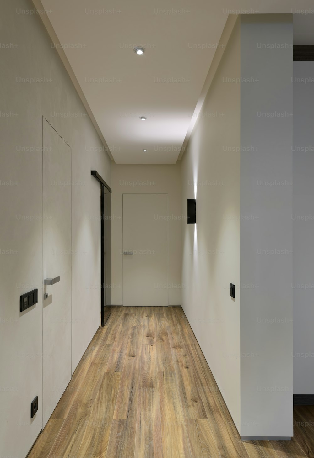 an empty hallway with a door and a light on
