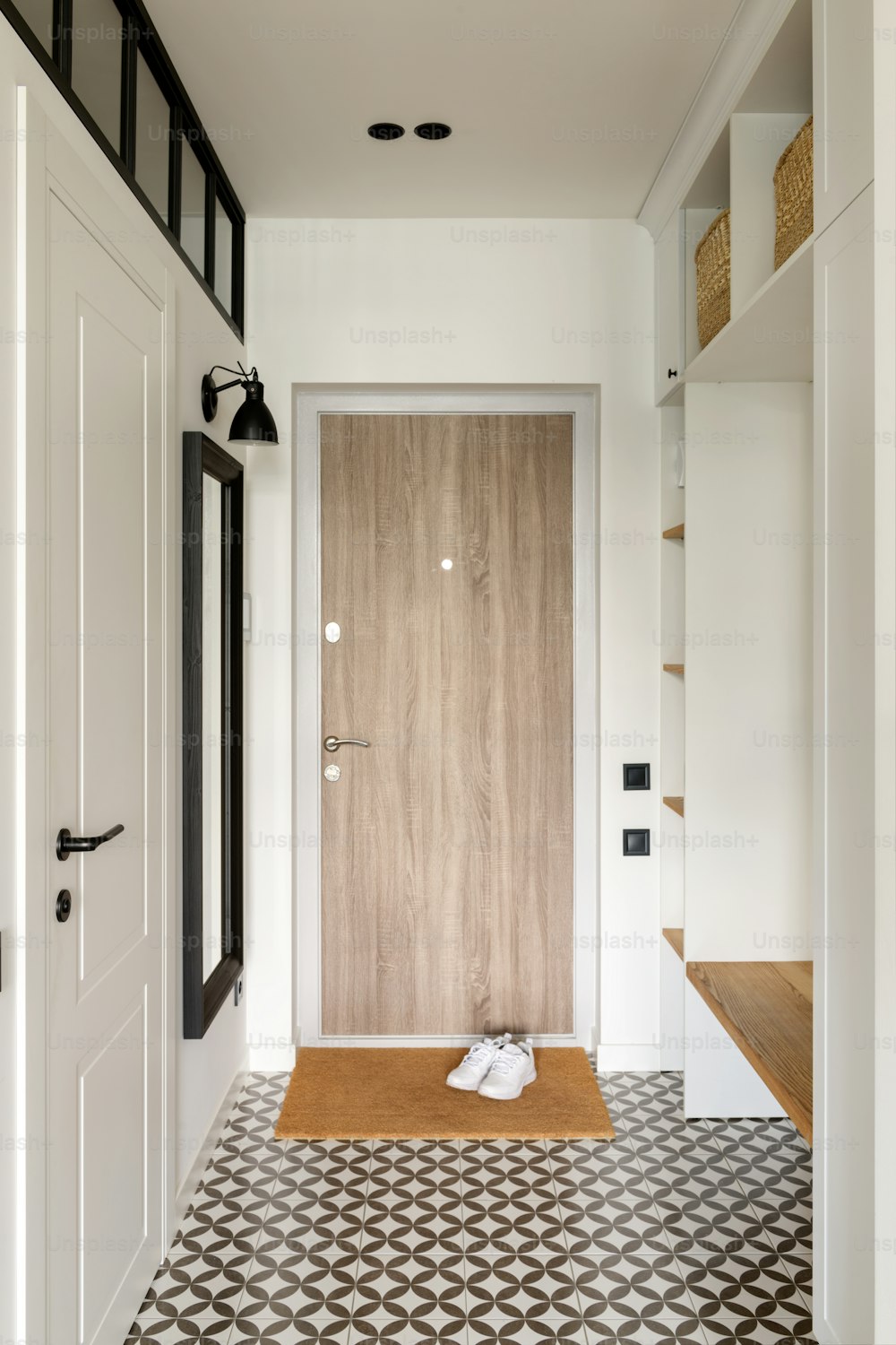 a hallway with a wooden door and black and white floor