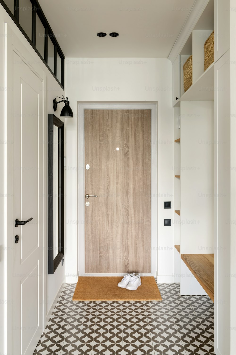 un corridoio con una porta in legno e pavimento in bianco e nero