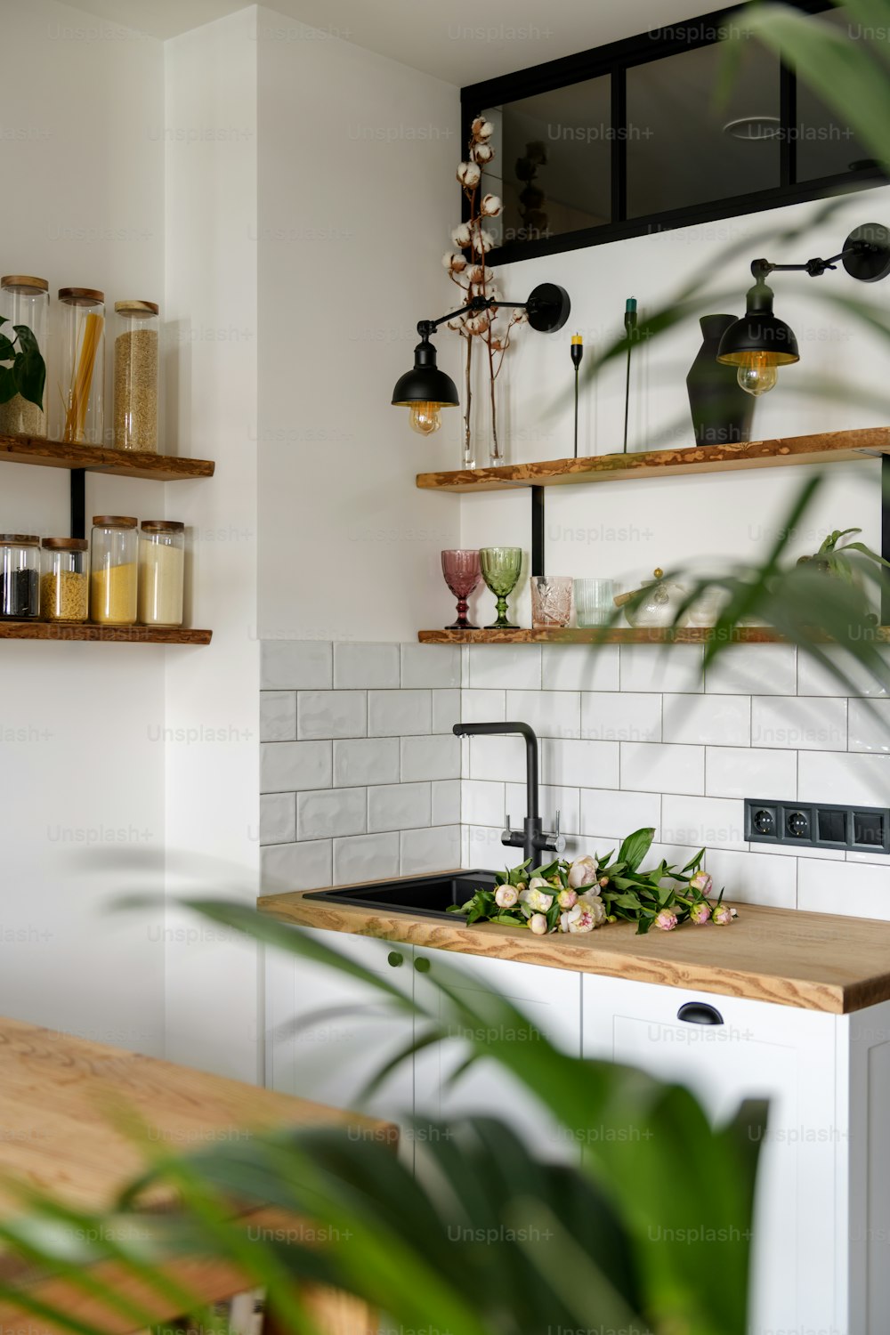 uma cozinha com uma bancada de madeira ao lado de uma planta