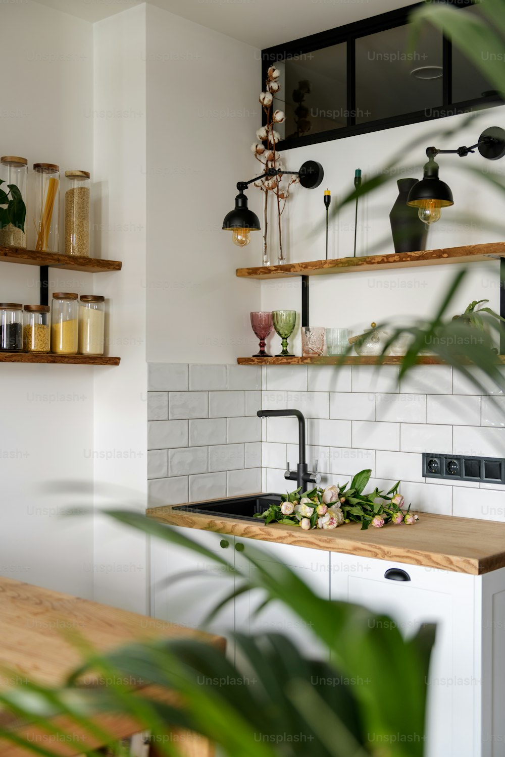 a kitchen with a wooden counter top next to a plant