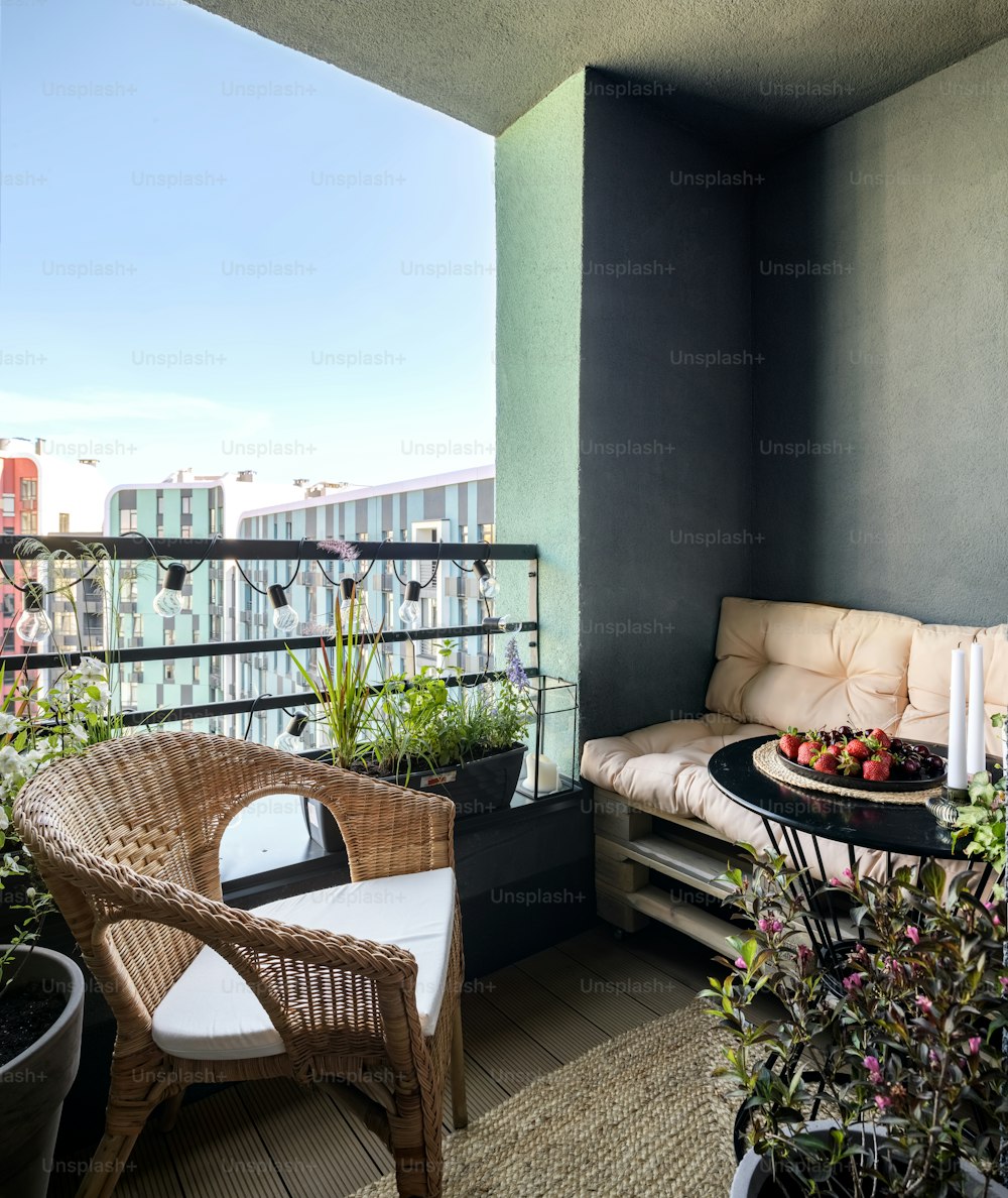 un balcón con sofá, mesa y plantas en macetas
