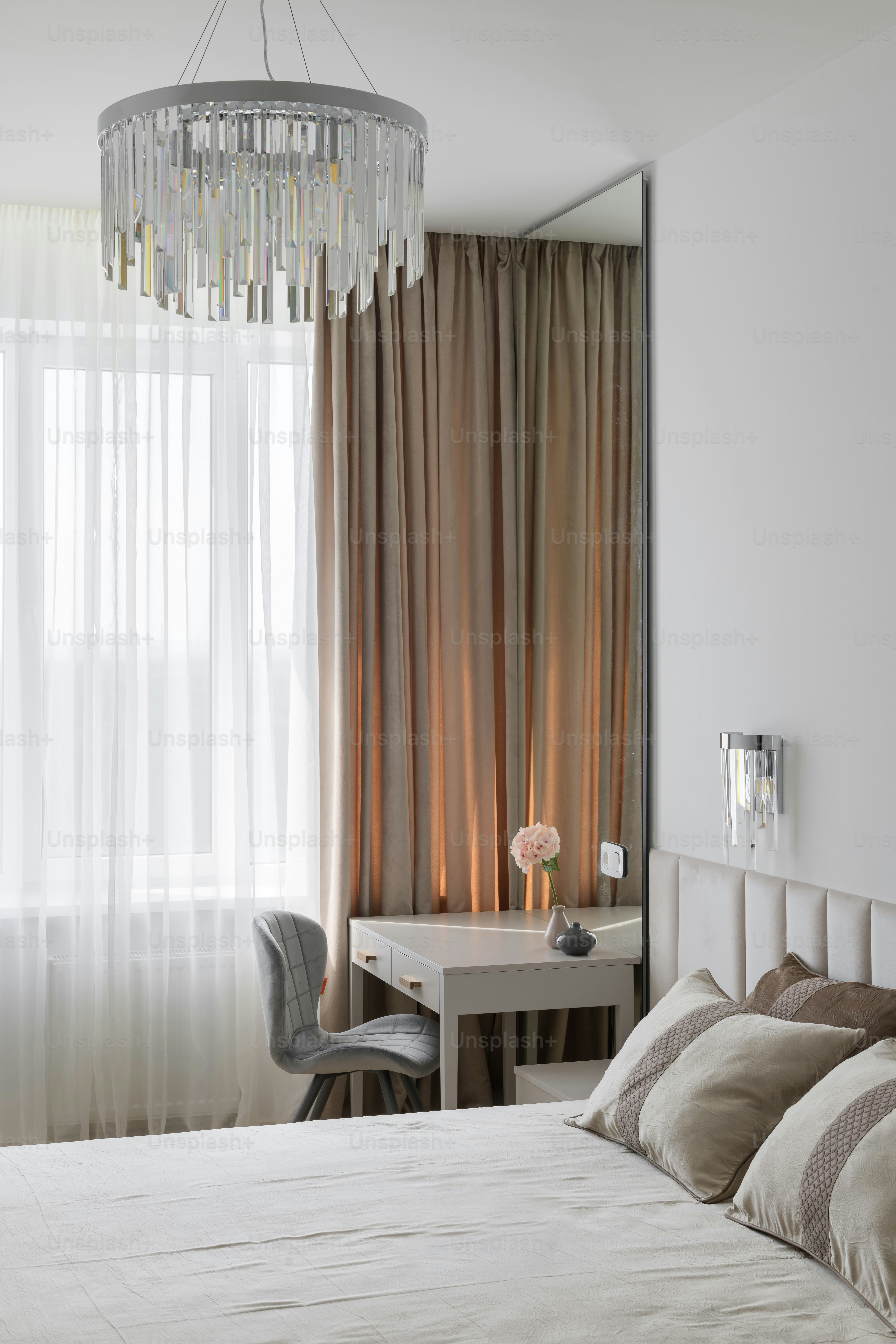 ベッド、机、椅子、シャンデリアのあるベッドルーム