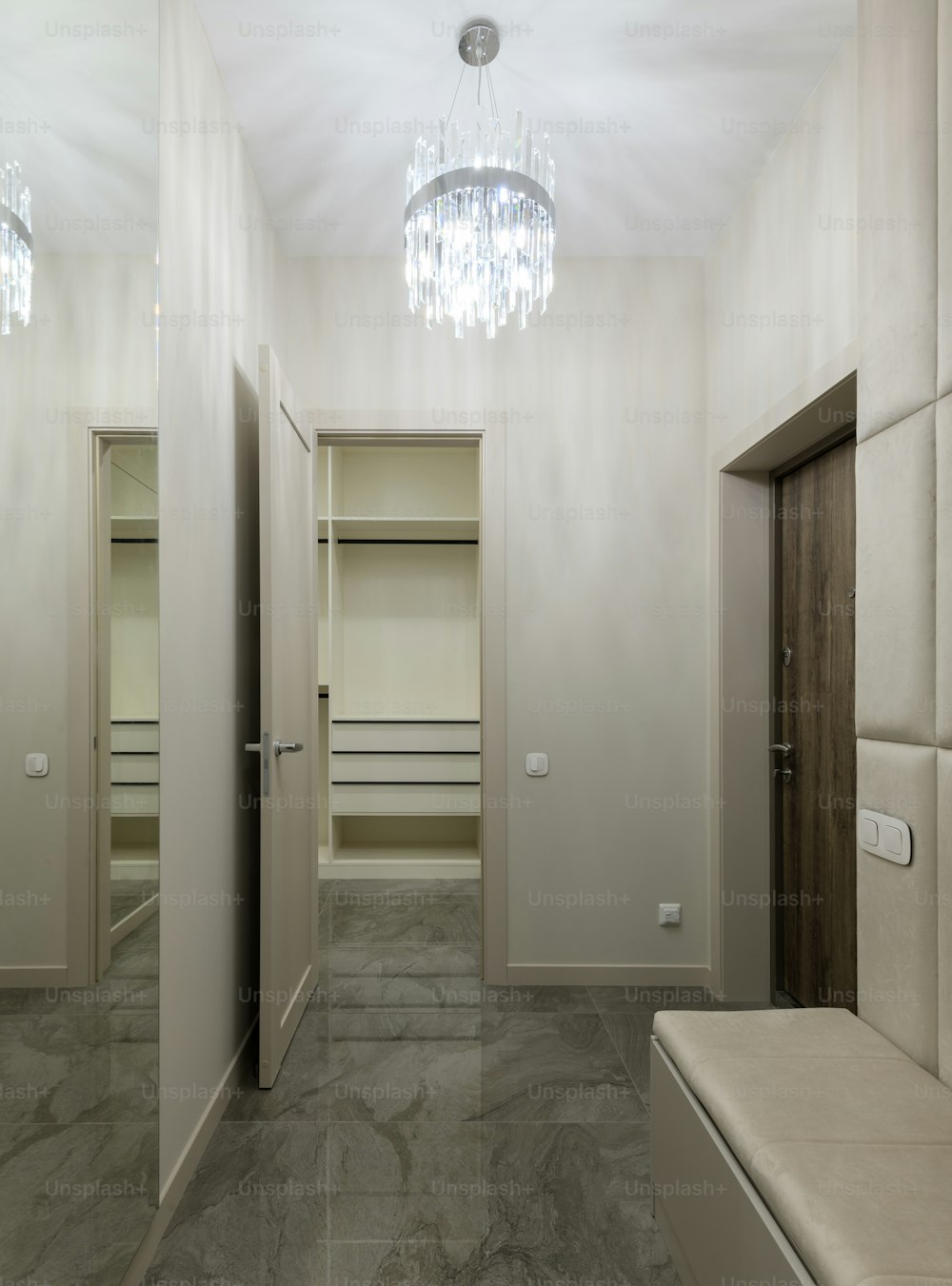 a hallway with a bench and a chandelier