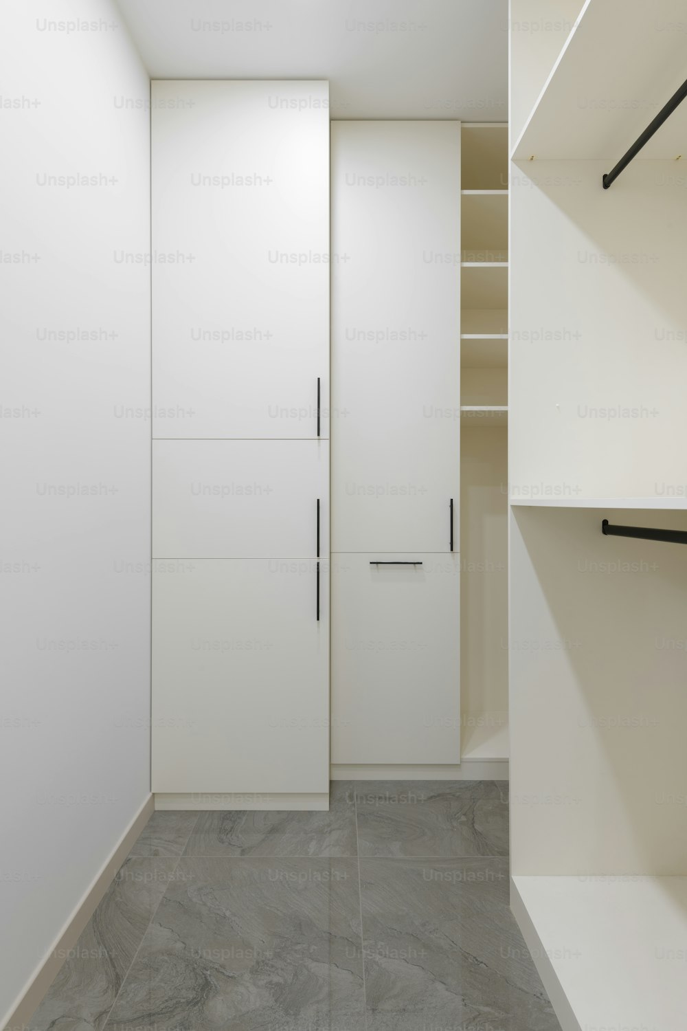 a walk in closet next to a white wall