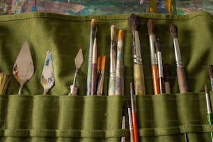 a green case filled with lots of paint brushes
