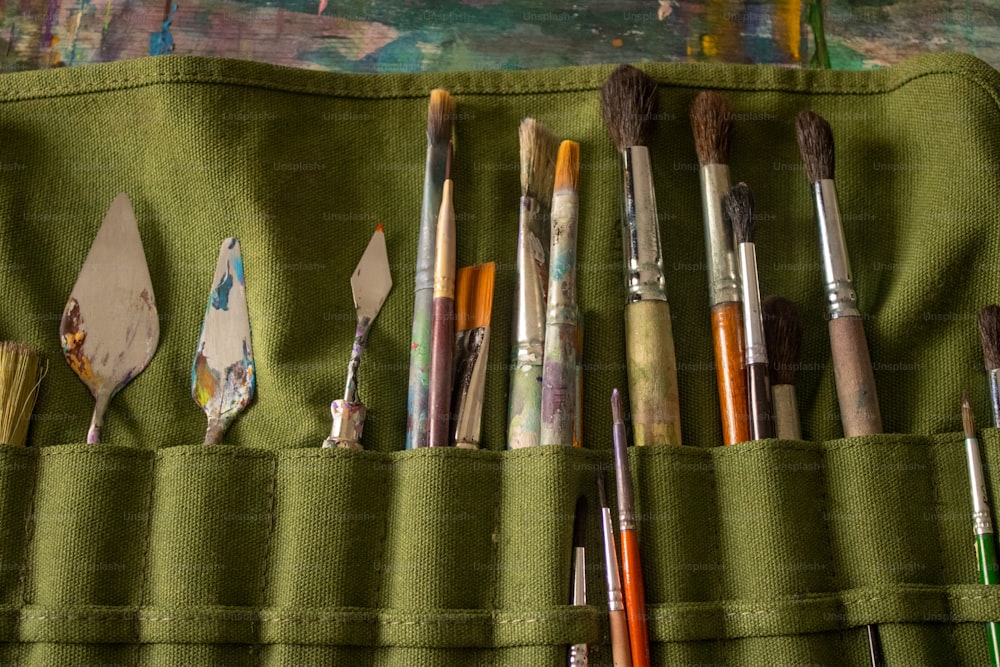 a green case filled with lots of paint brushes