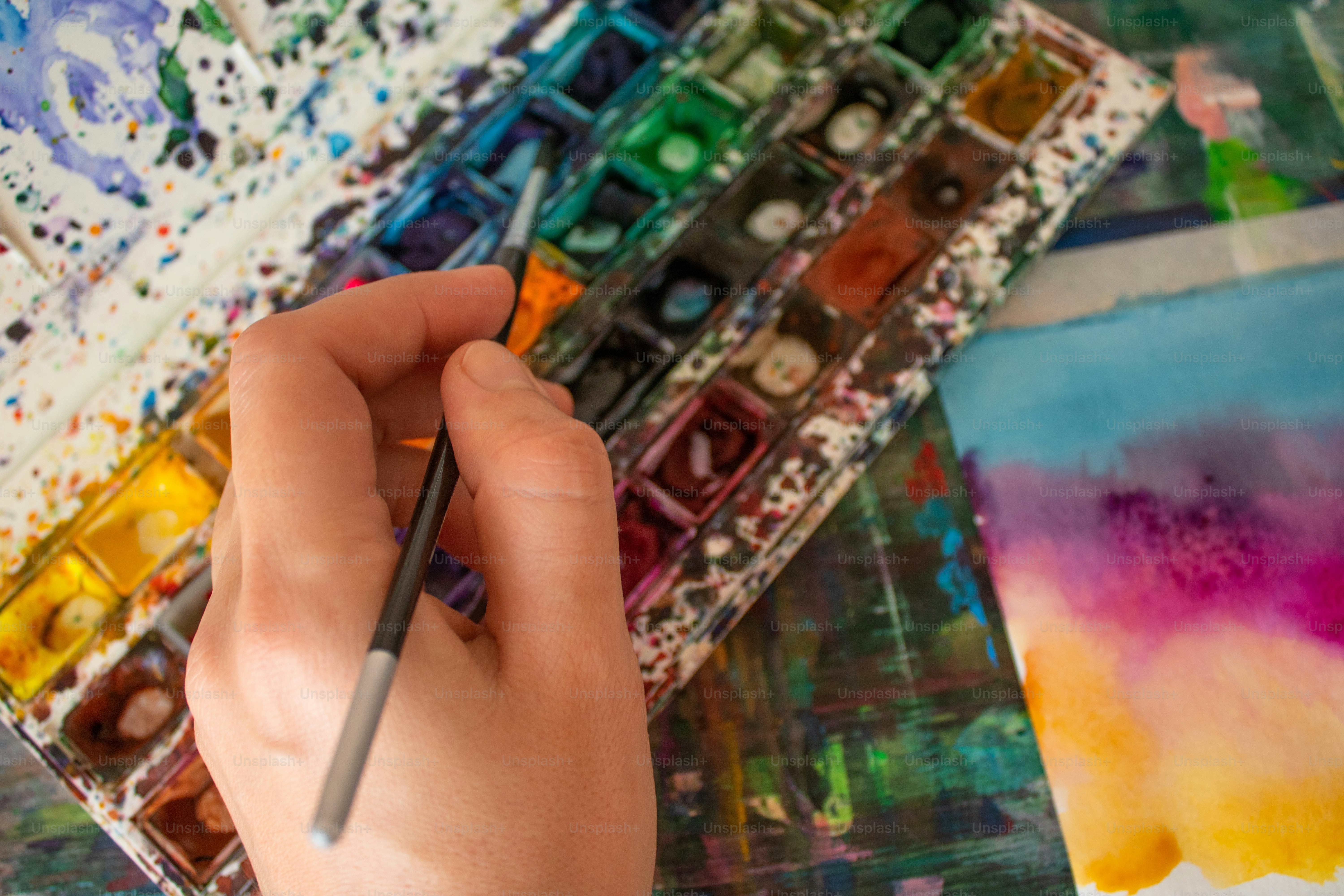 uma pessoa está segurando um pincel na mão