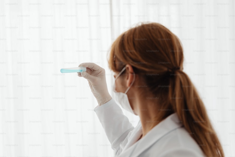 a woman in a white lab coat holding a toothbrush