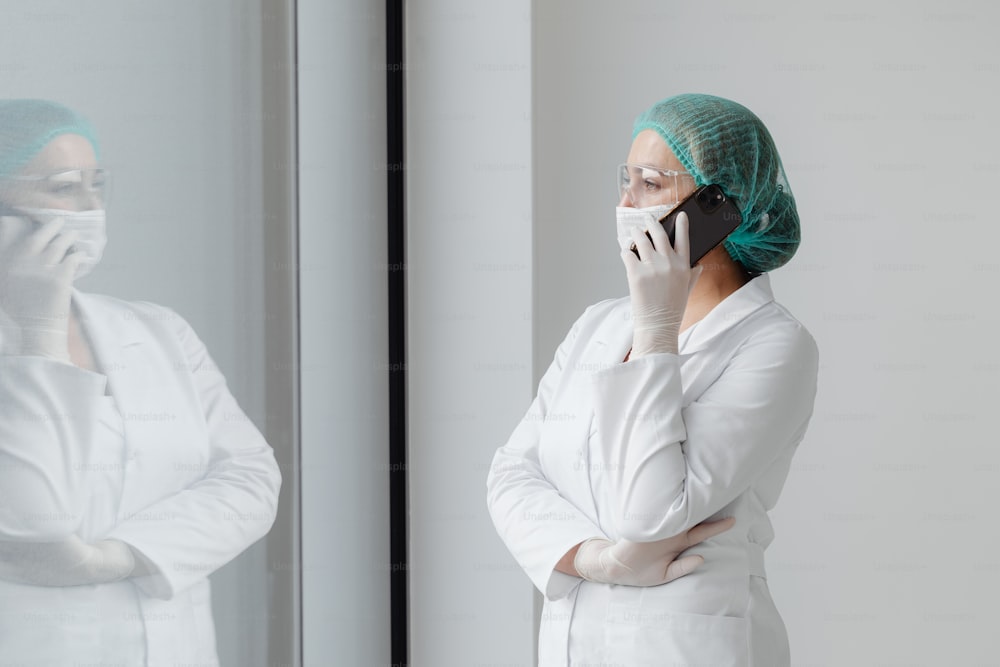 a woman in a white lab coat talking on a cell phone