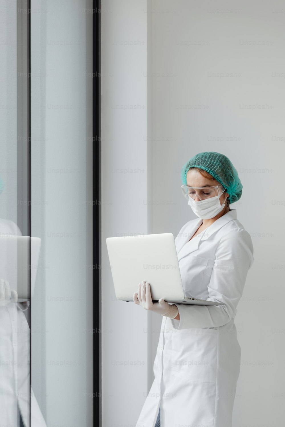 흰색 실험실 코트를 입은 여성이 노트북을 사용하고 있다
