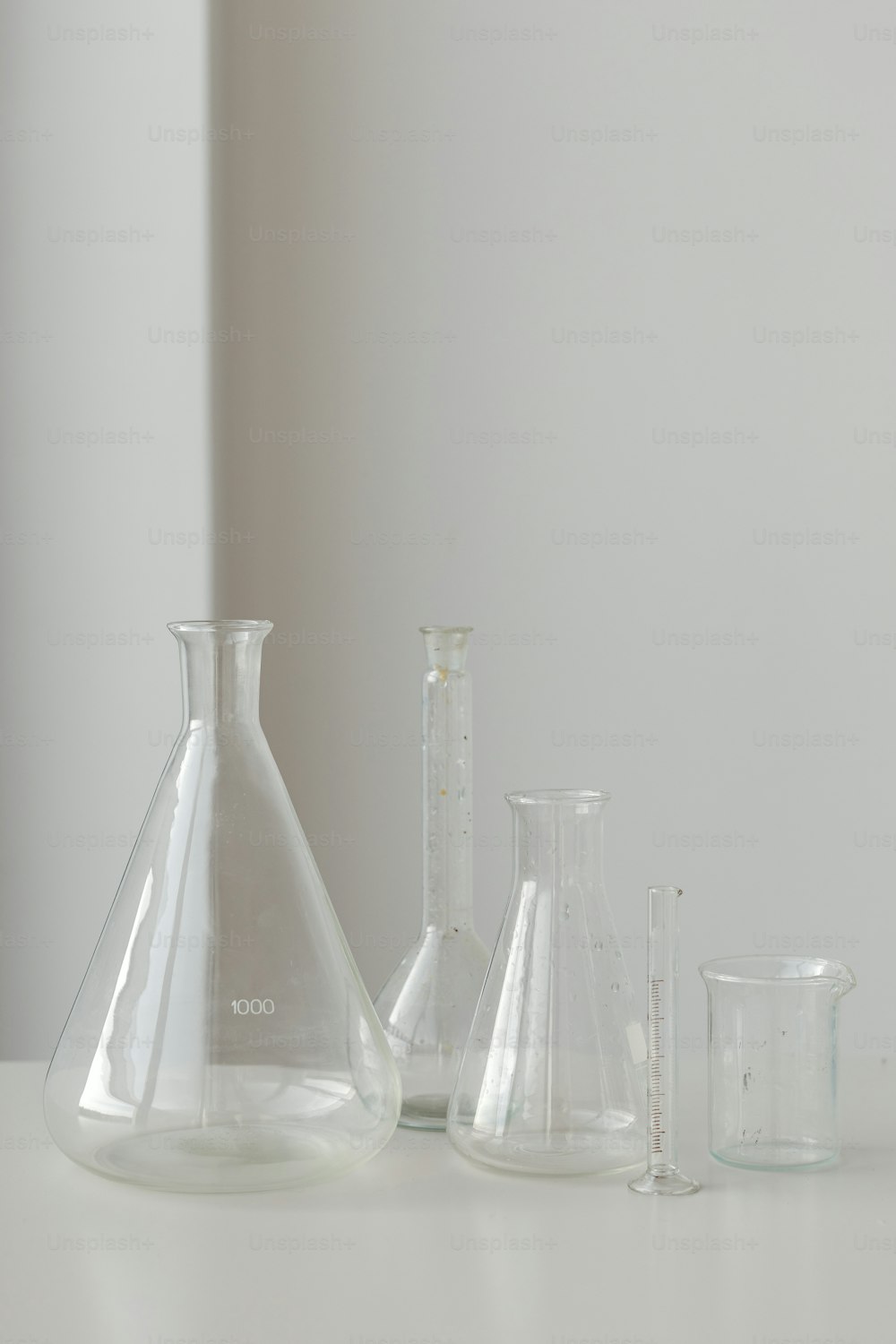 3つのガラスの花瓶で覆われた白いテーブル