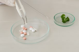 a person in white gloves is putting pills in a glass bowl
