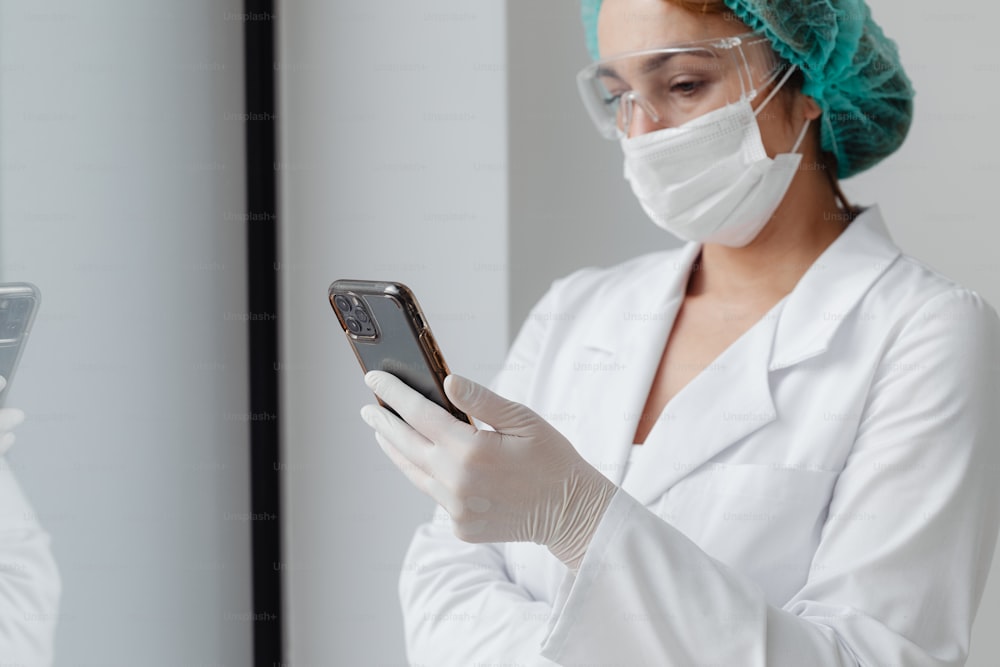 a woman in a white lab coat holding a cell phone