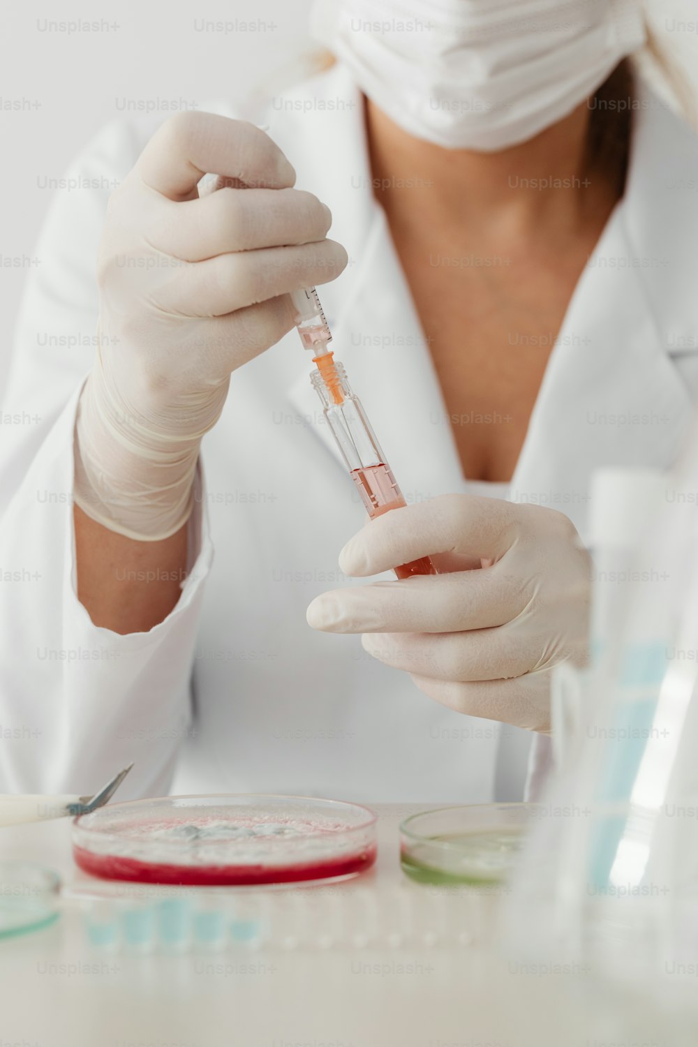 a woman in a white lab coat is holding a test tube