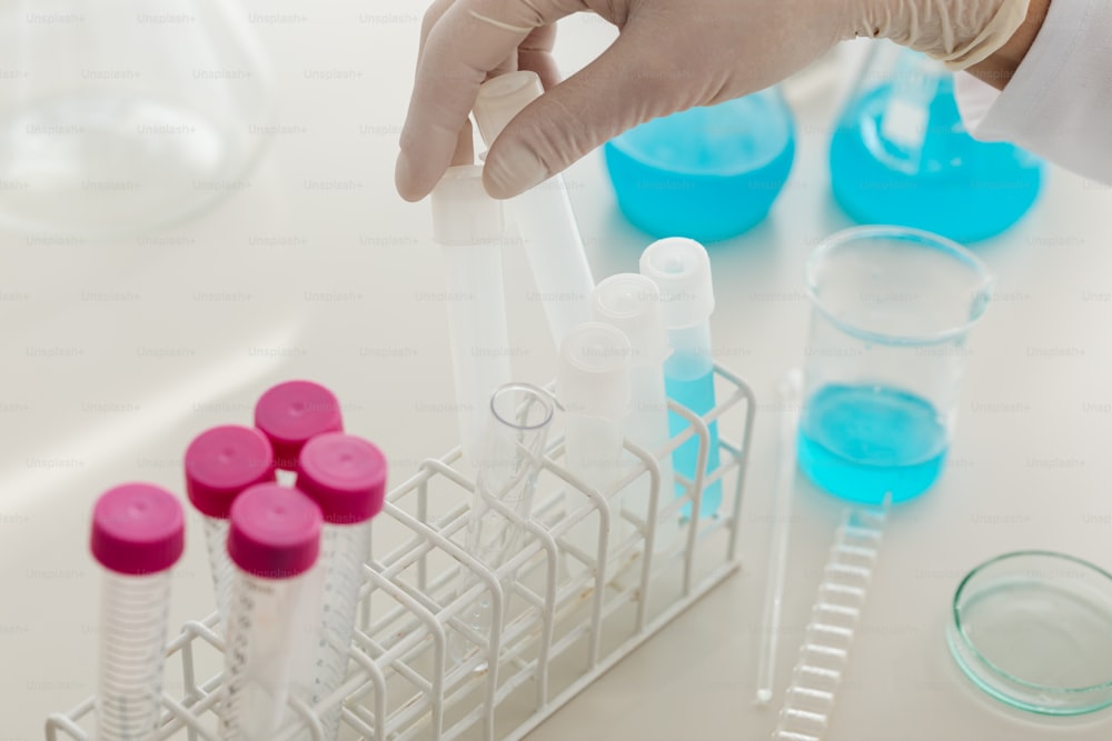 a person holding a pipe in front of a rack of test tubes