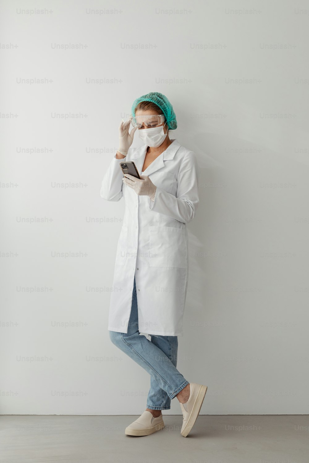 a woman wearing a white lab coat and mask