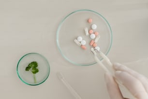 a person holding a toothbrush in front of a plate of pills