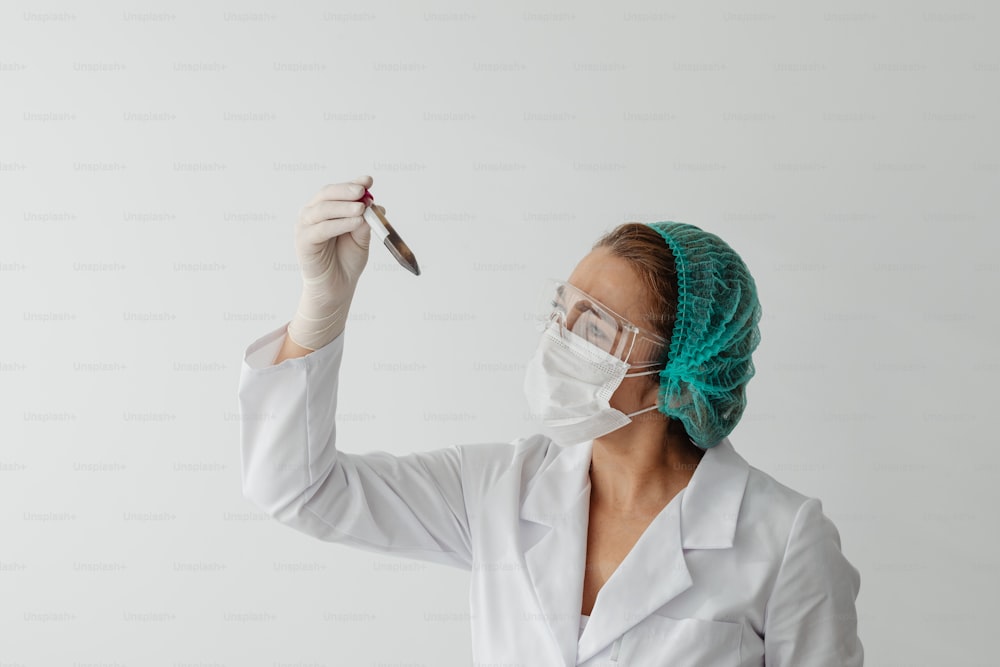 a woman in a white lab coat holding a pair of scissors