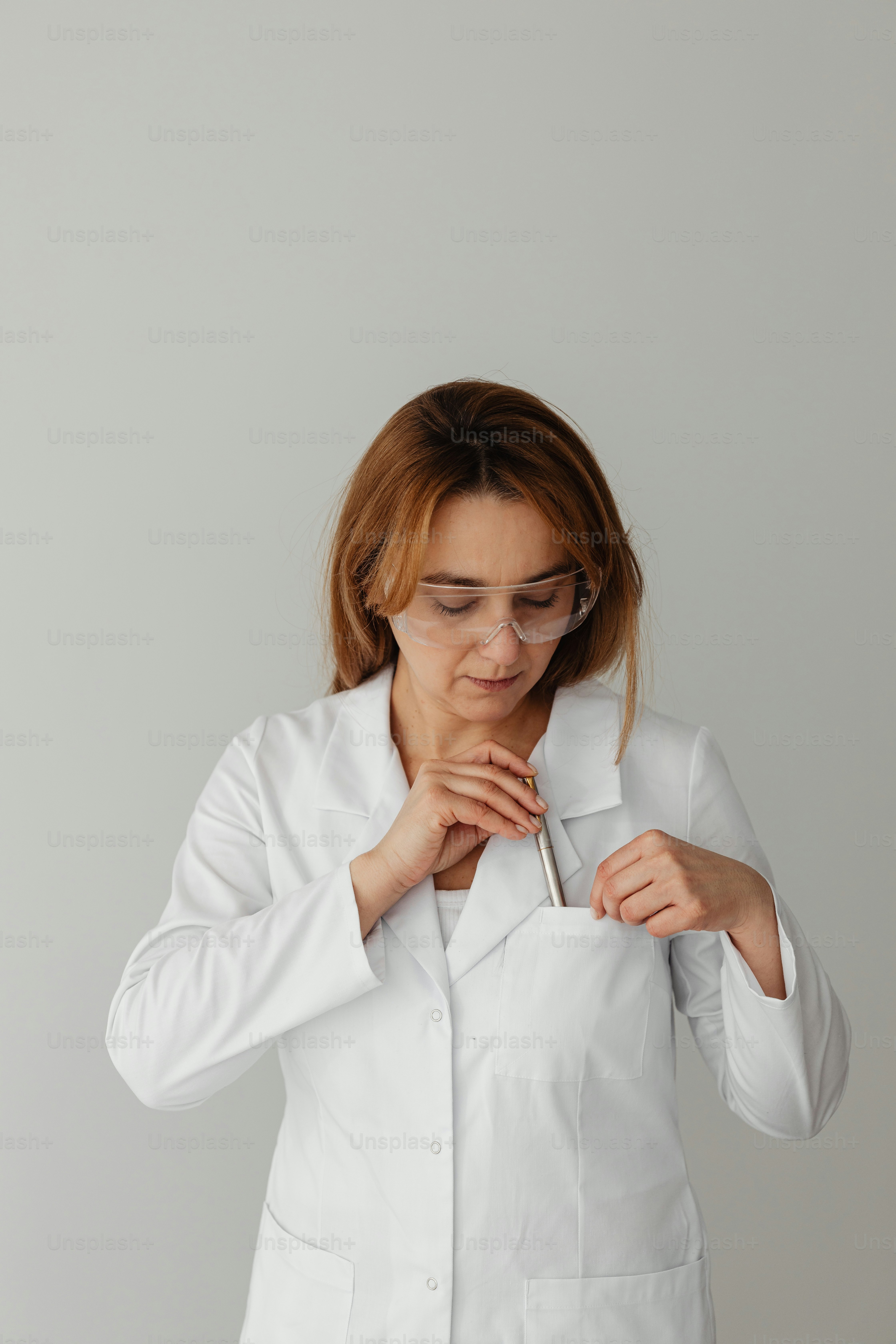 a woman in a white lab coat holding a pair of scissors