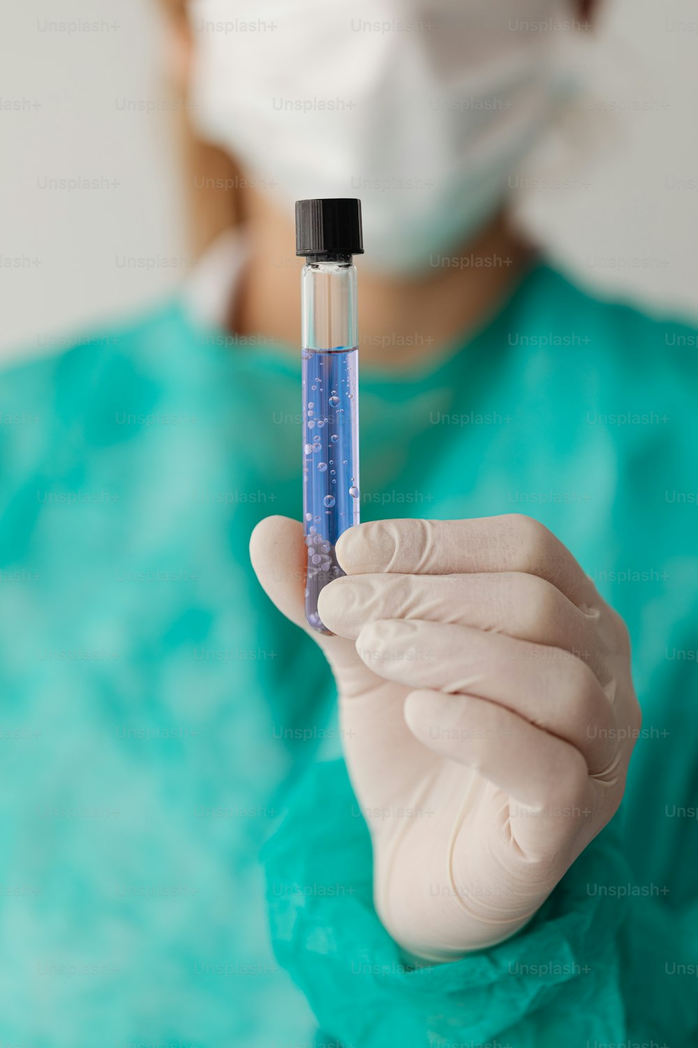 a person in a hospital gown holding a small tube