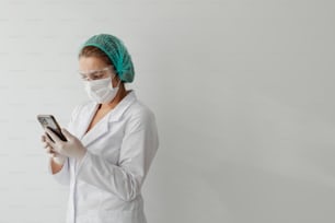 una donna che indossa una maschera chirurgica e tiene in mano un telefono cellulare