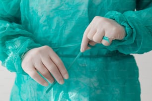 Una persona con un vestido verde sosteniendo un par de tijeras