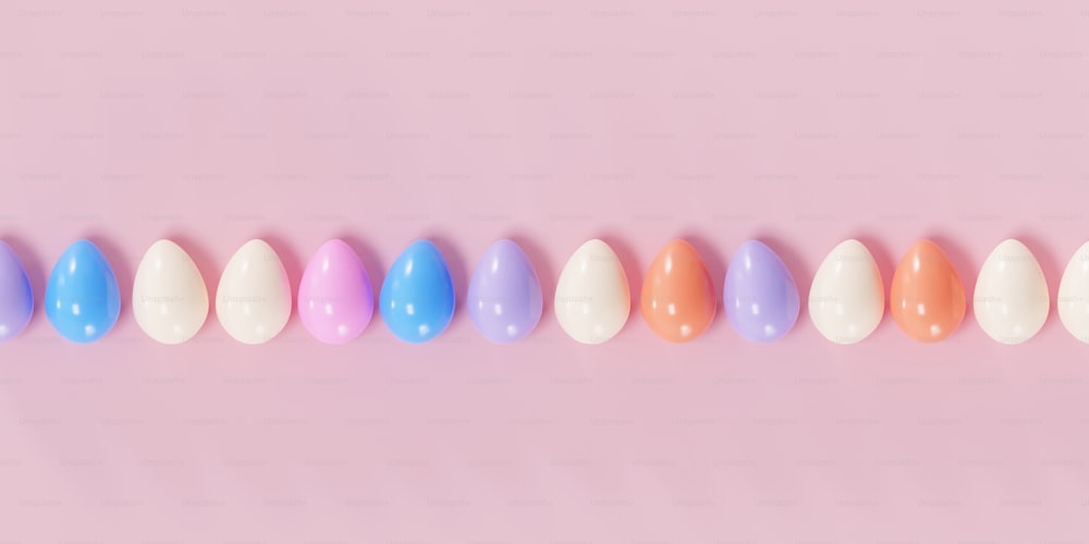 a row of colored eggs on a pink background