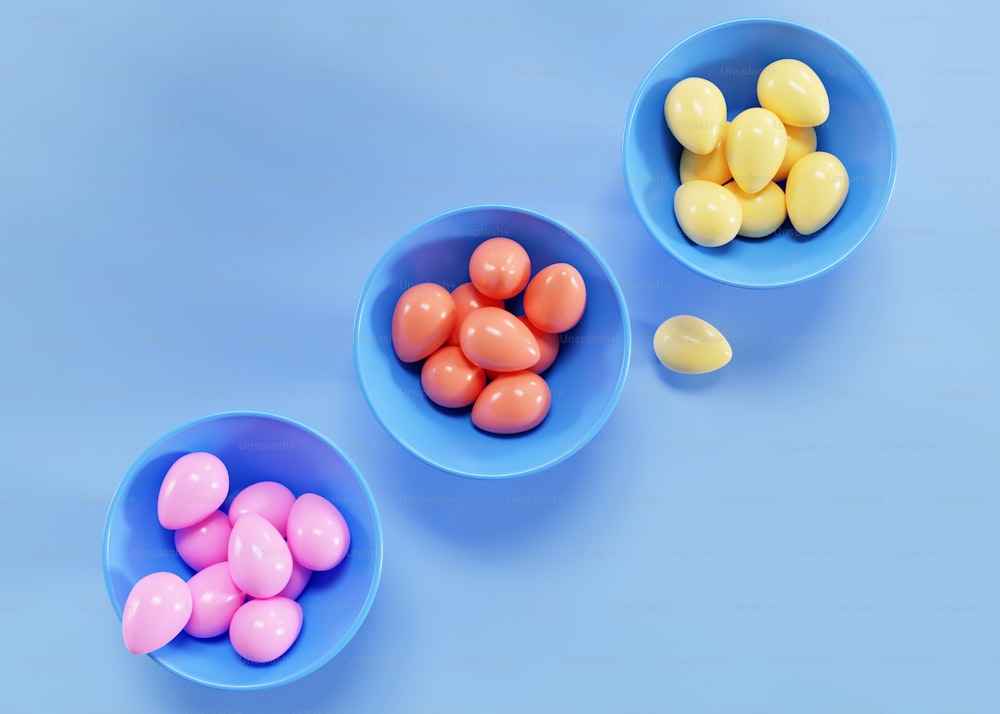 three bowls filled with candy on a blue background
