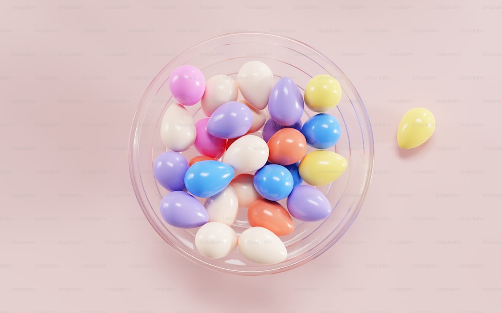 a bowl filled with colorful candy on top of a pink surface