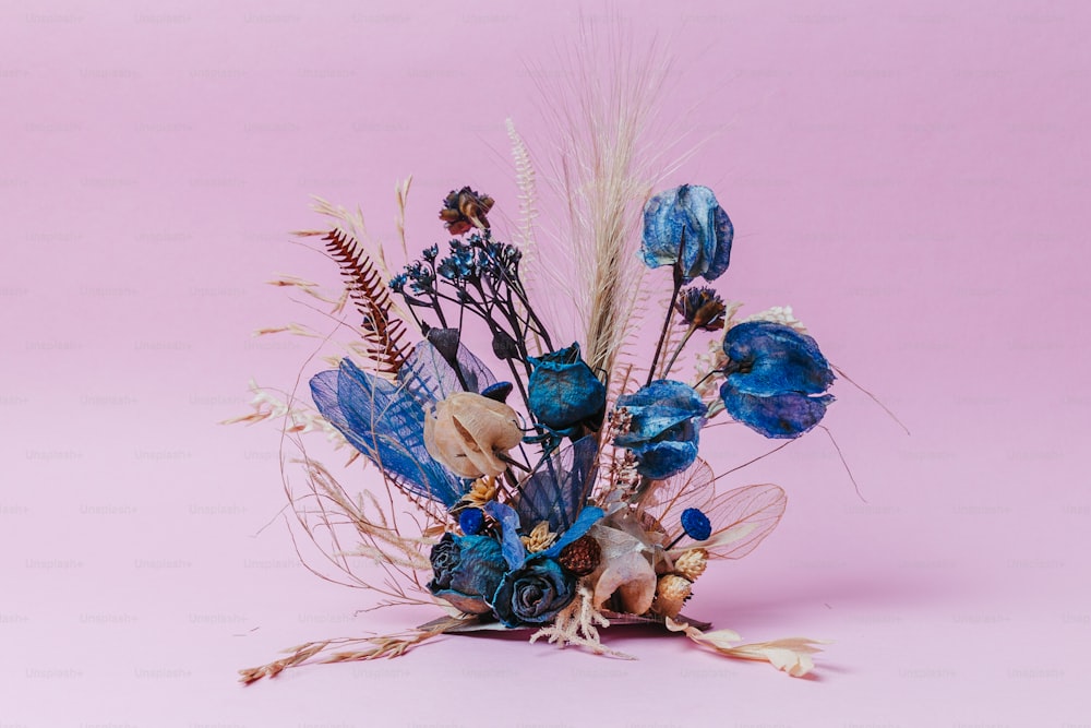 a bouquet of blue flowers on a pink background