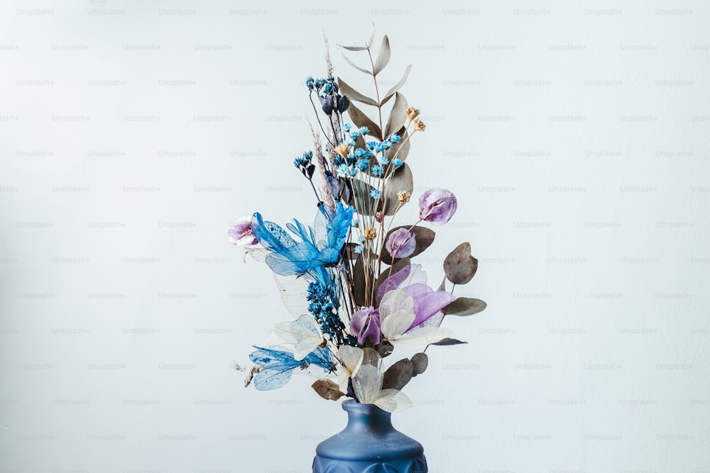 a blue vase with a bunch of flowers in it