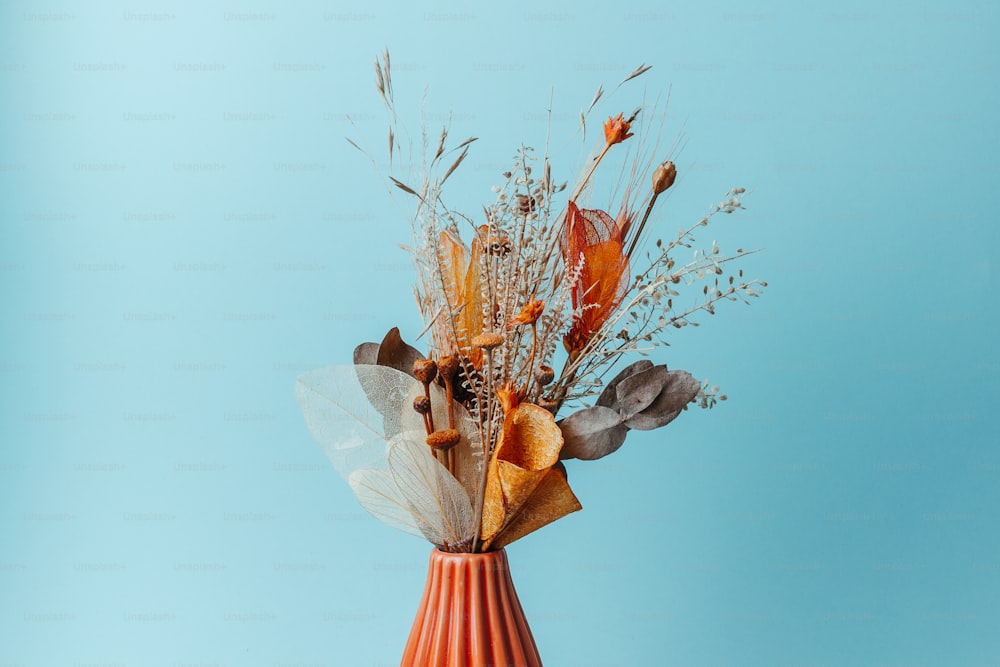 un vase rempli de fleurs séchées sur une table