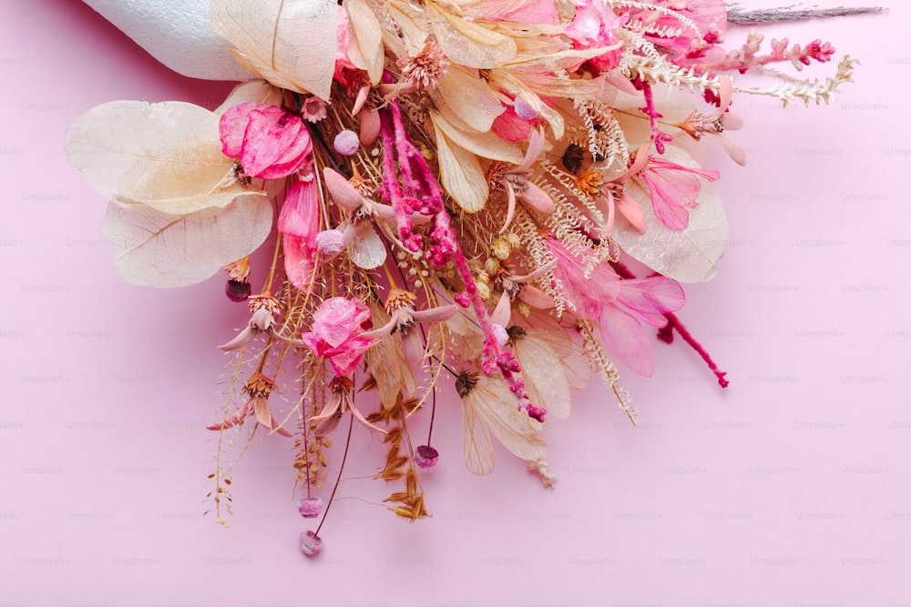 un mazzo di fiori che si trovano su una superficie rosa