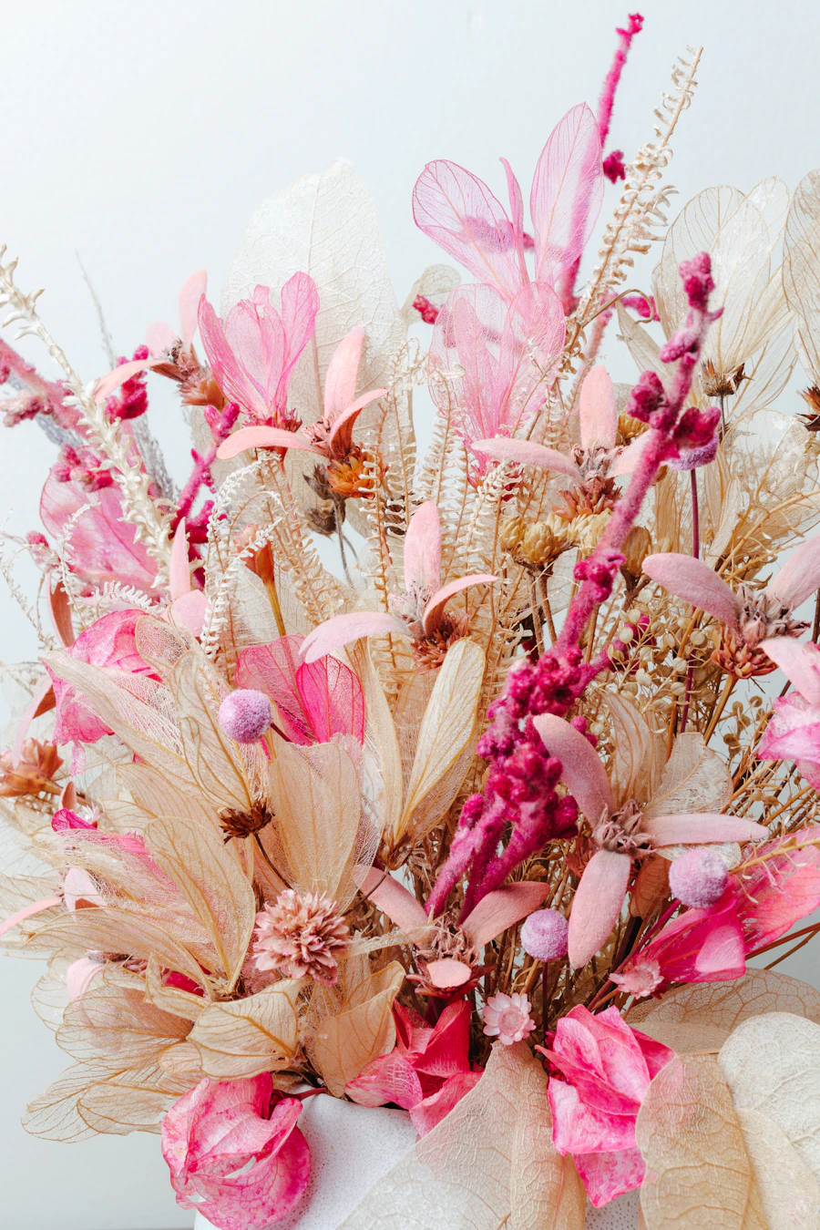 Mains d'une fleuriste composant un bouquet de roses et pivoines