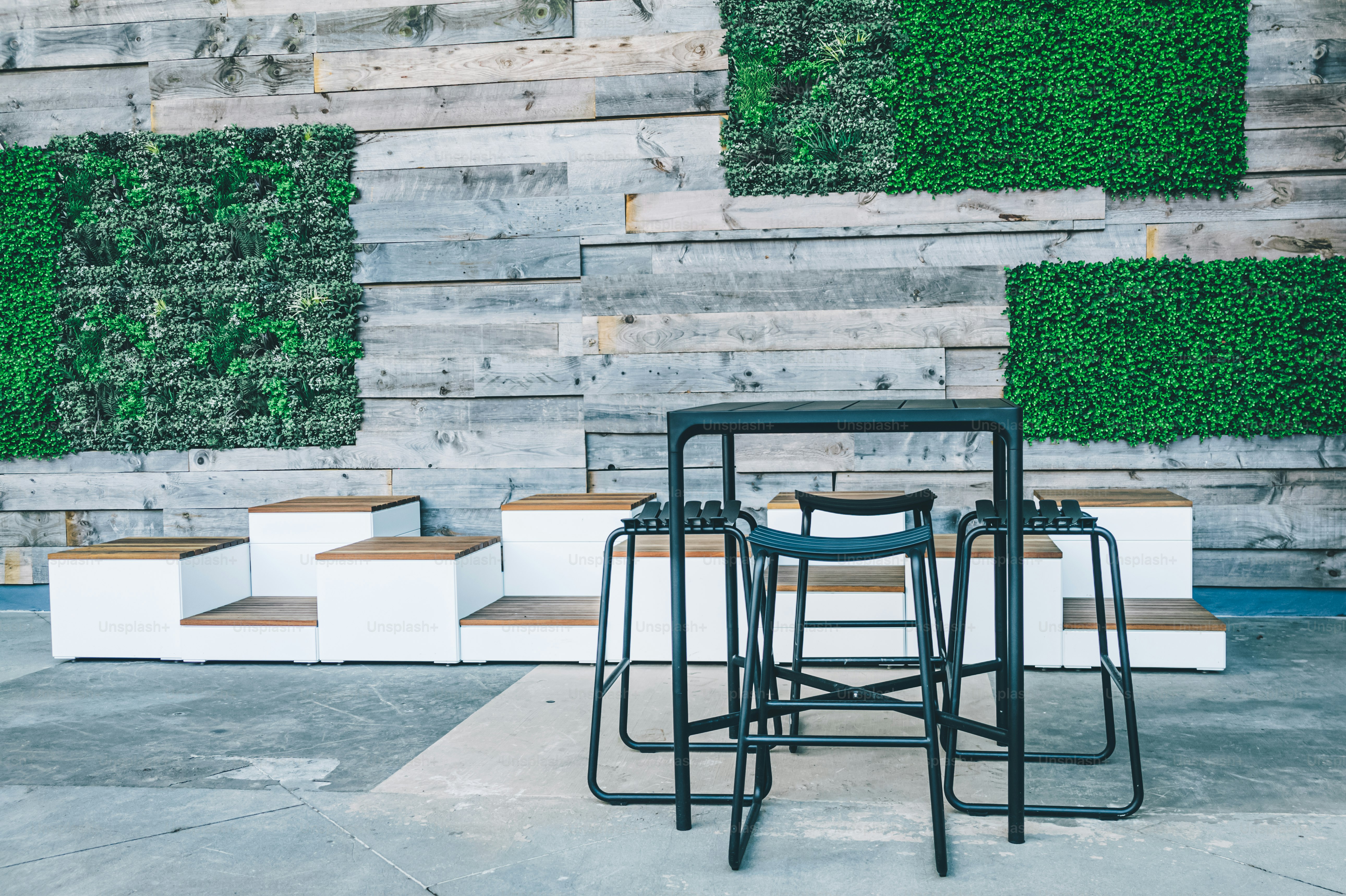 a set of four stools sitting in front of a wooden wall