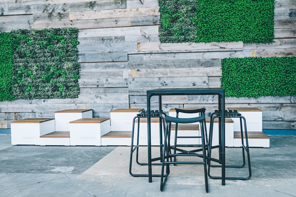 a set of four stools sitting in front of a wooden wall