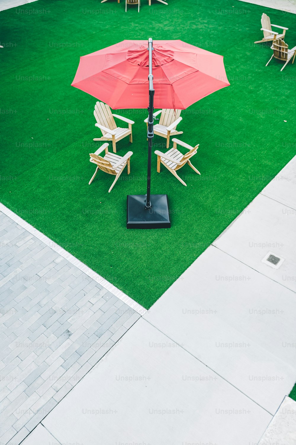 a lawn with lawn chairs and an umbrella