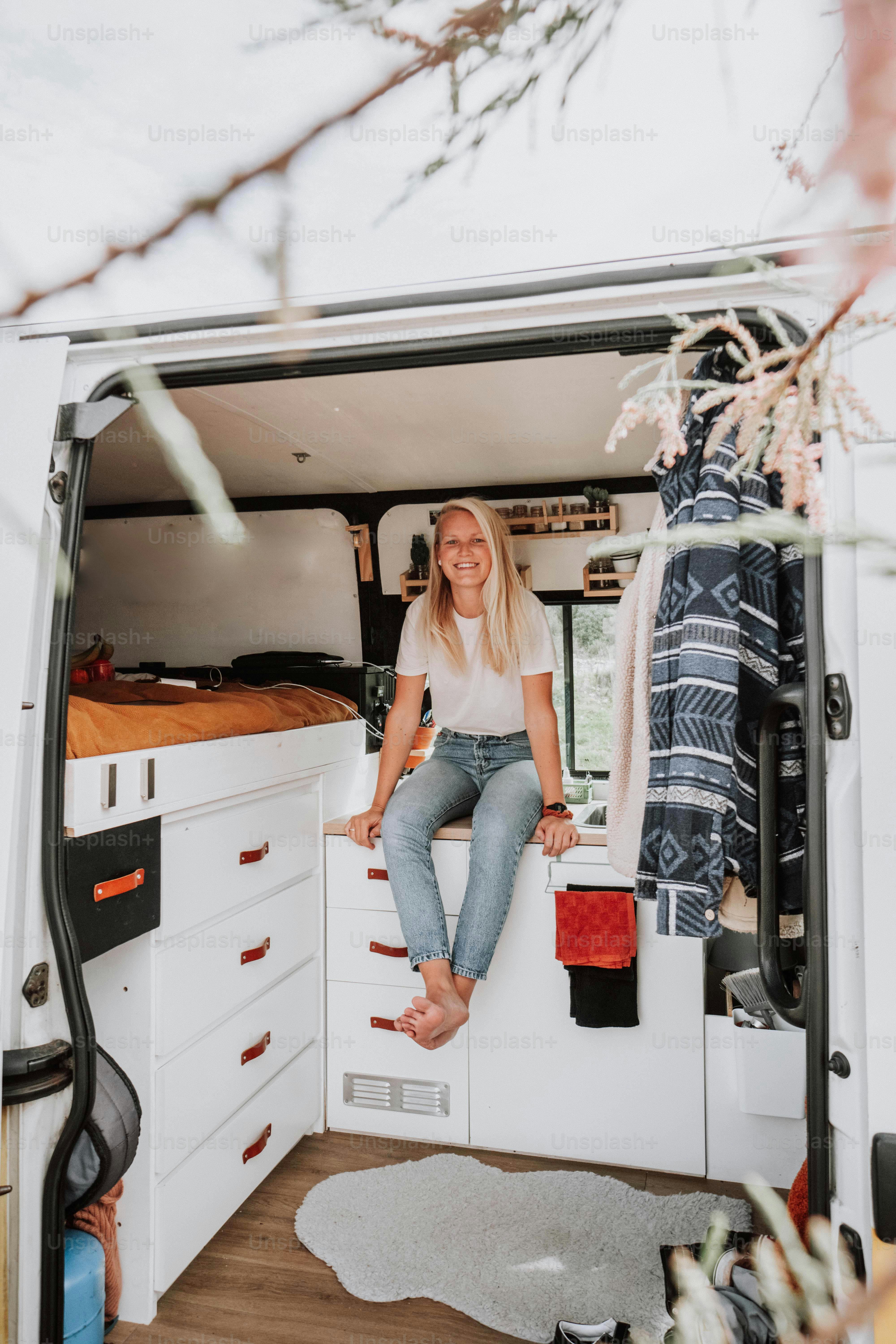 Una donna seduta sul retro di un furgone