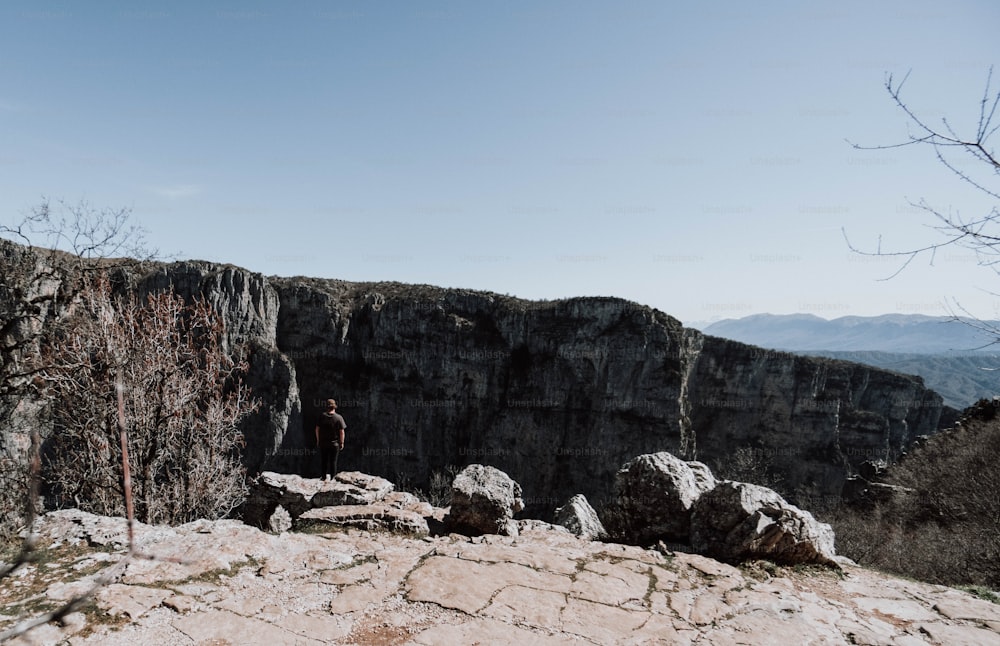 a man standing on top of a rocky cliff