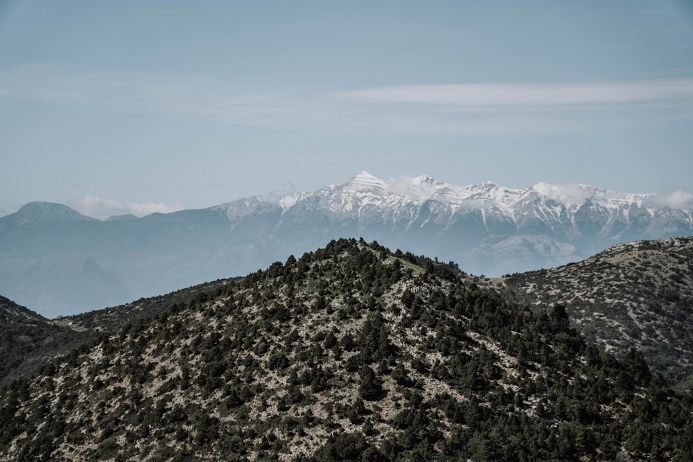 une vue d’une chaîne de montagnes avec des montagnes enneigées au loin