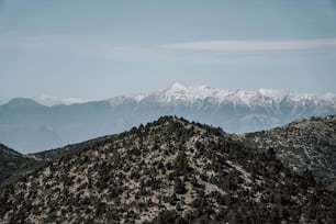 a view of a mountain range with snow capped mountains in the distance