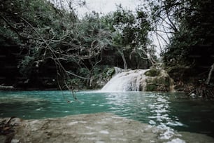 uma pequena cachoeira no meio de um corpo de água
