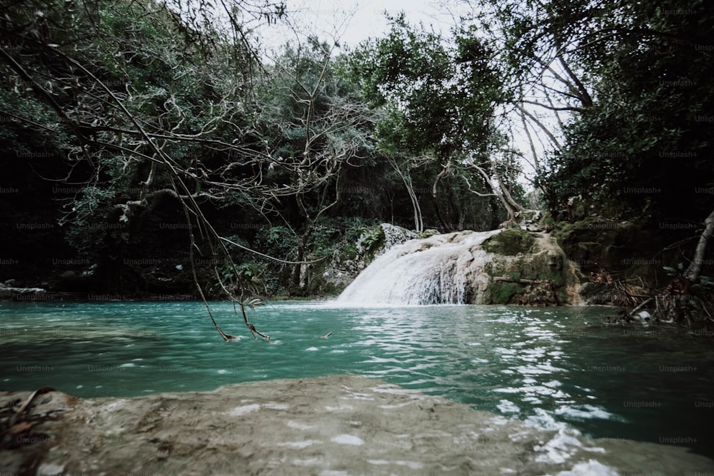 a small waterfall in the middle of a body of water