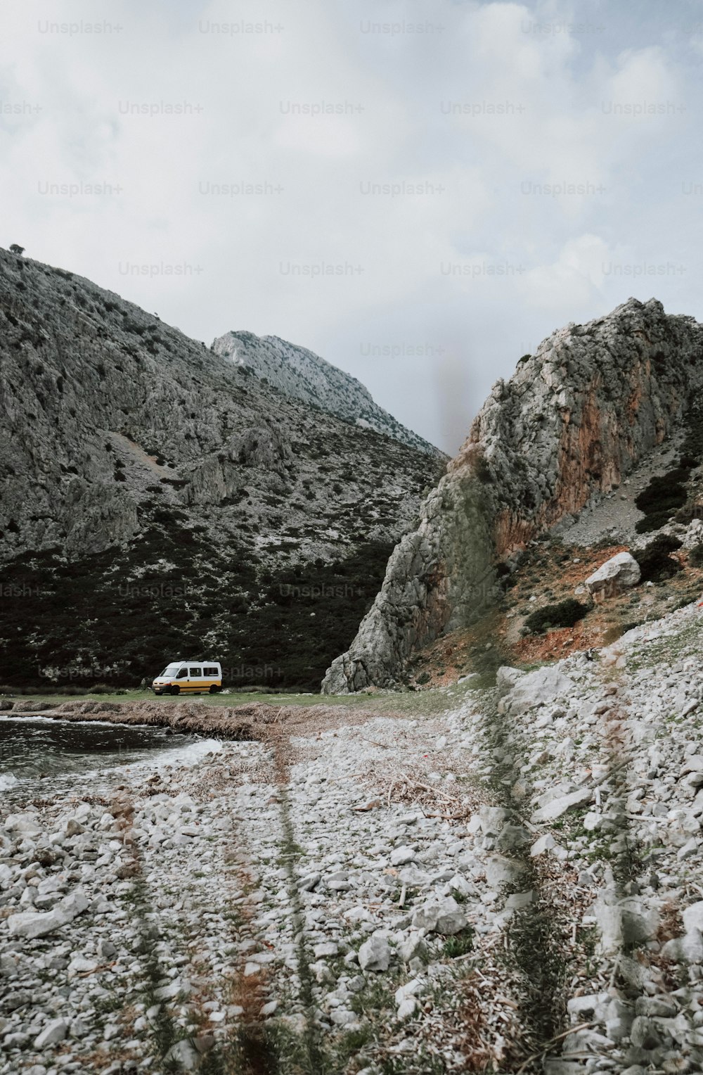 a van is parked in the snow near a mountain